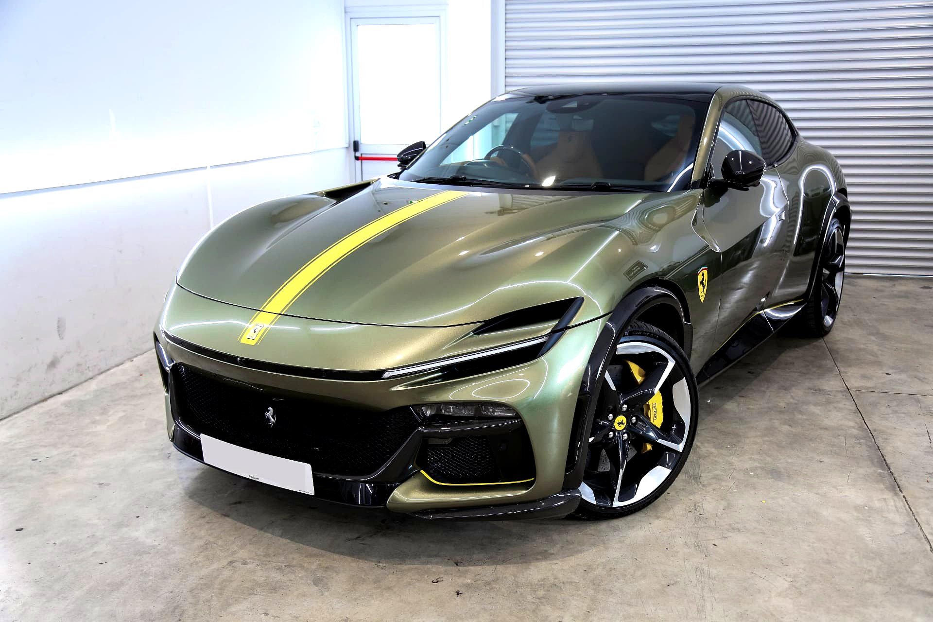 Matte green Ferrari Purosangue with yellow racing stripe wrap